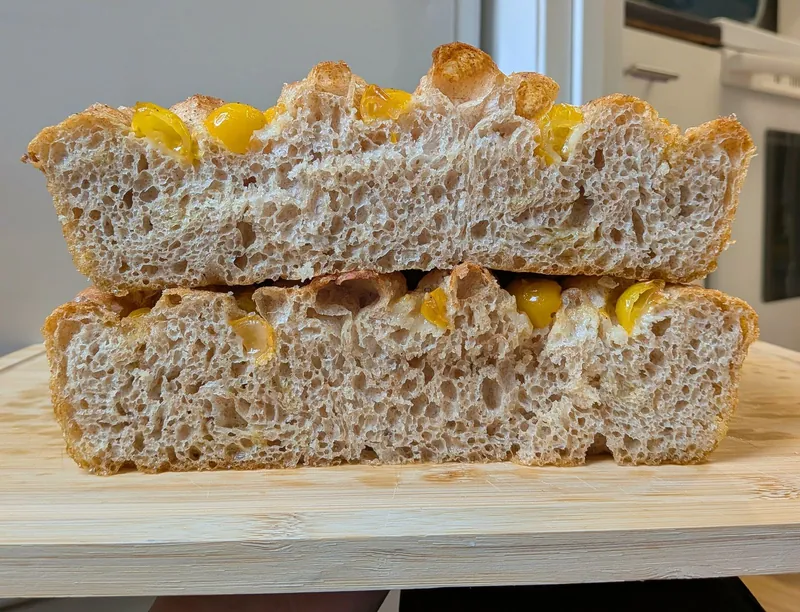 focaccia with golden cherry tomatoes, cut and stacked to show the crumb