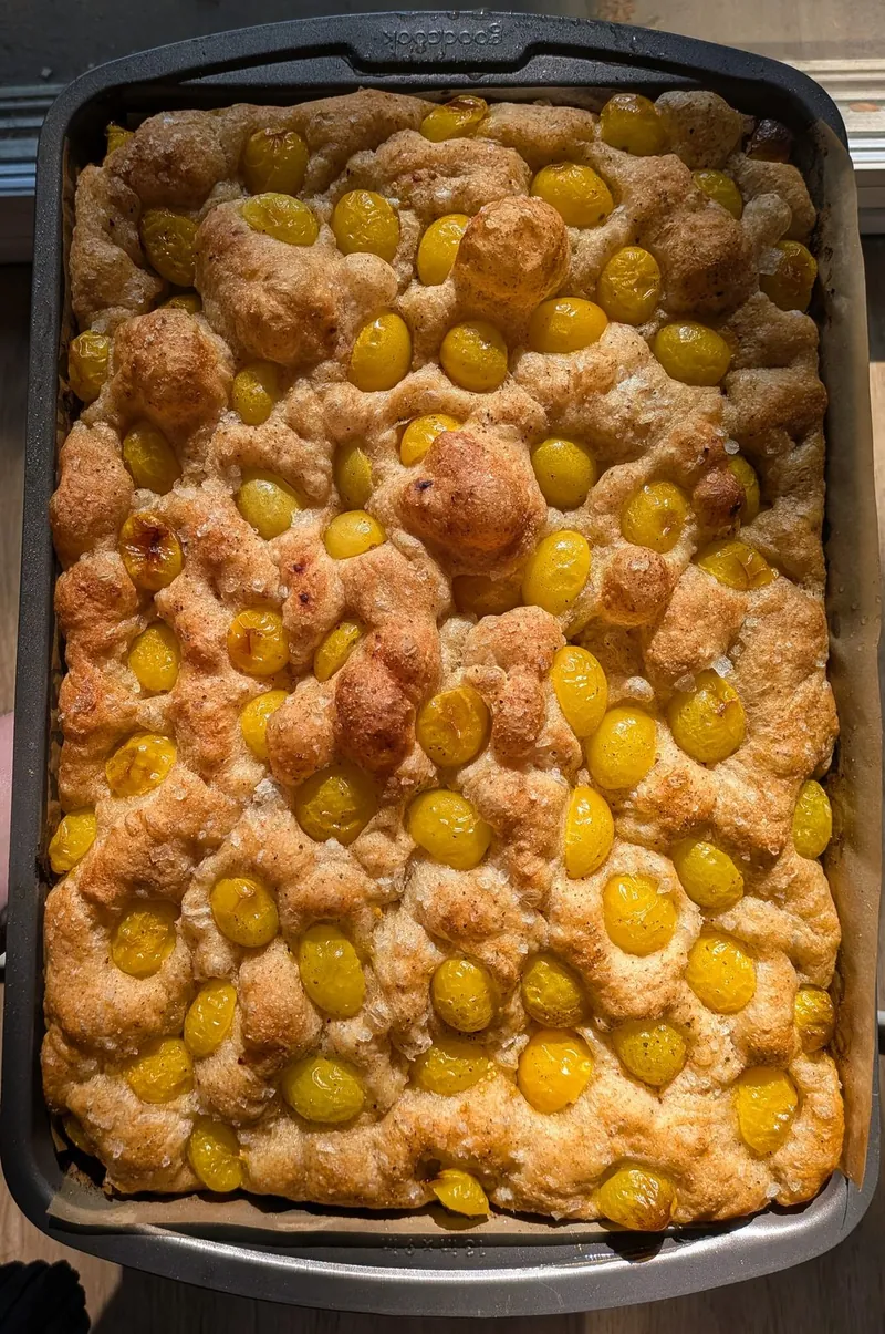 a pan of focaccia baked with golden cherry tomatoes