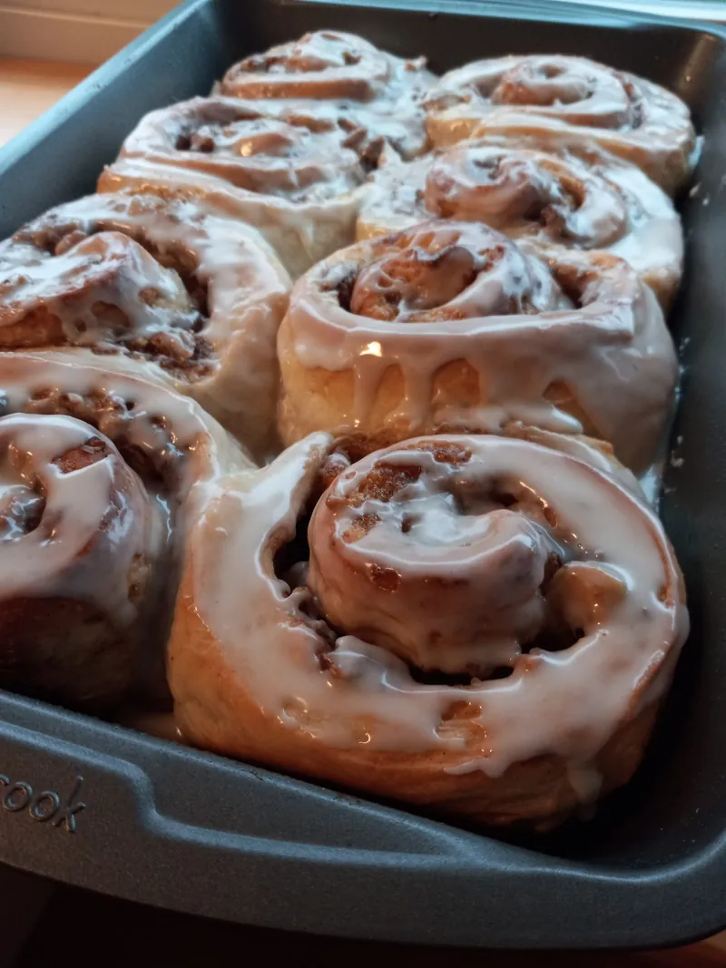 a pan of cinnamon rolls with white icing