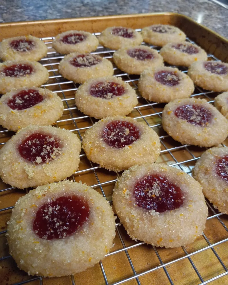 sugar-rolled jam thumbprint cookies on a cooling rack