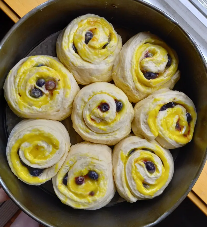 lemon blueberry milk bread cinnamon rolls in a round pan, before baking