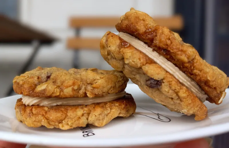 two oatmeal cream pie cookies with cream filling, on a white plate