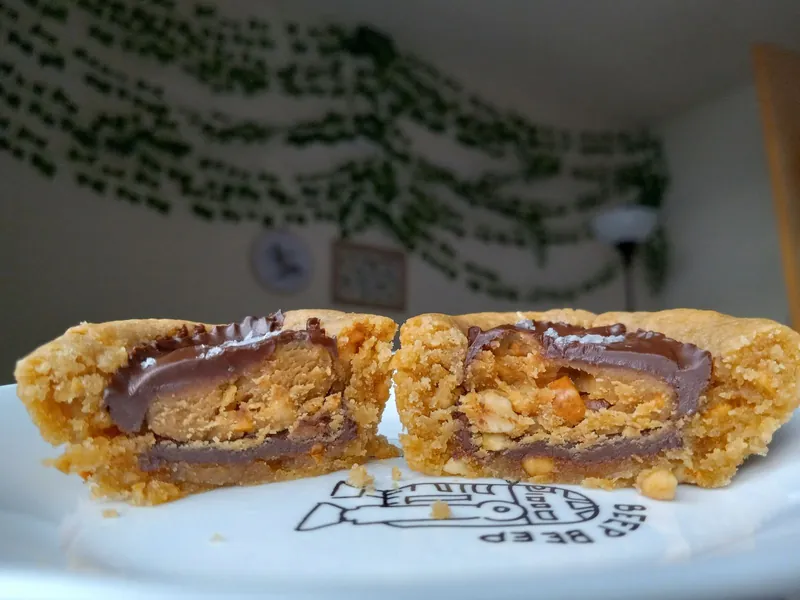a peanut butter cookie cut in half to show a peanut butter cup inside