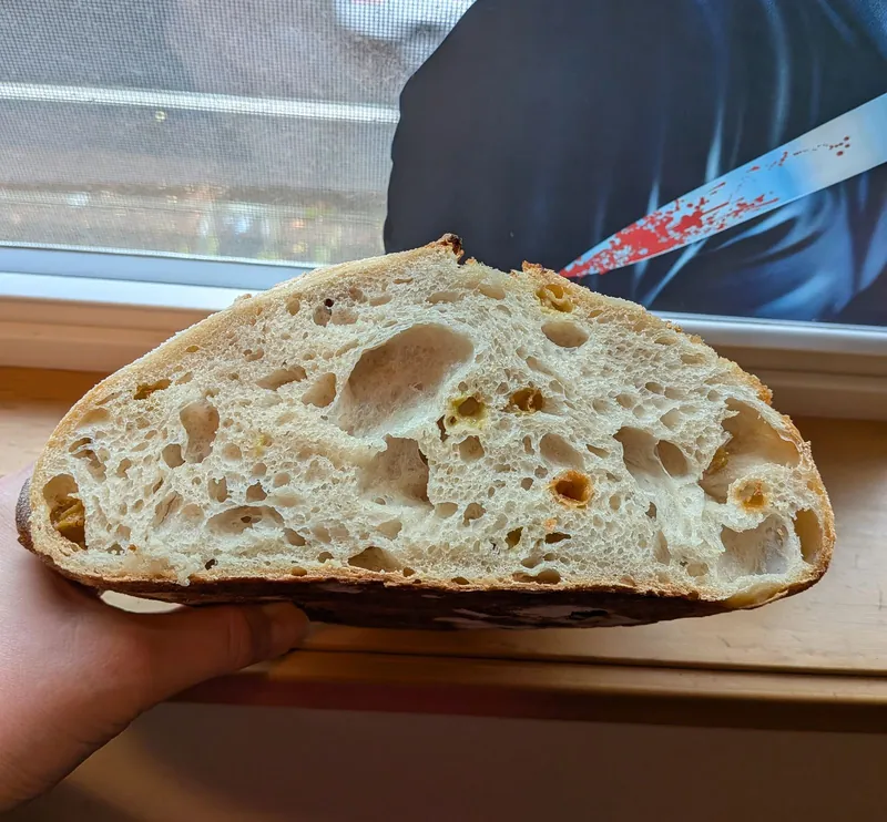 half a sourdough loaf held up to show the crumb